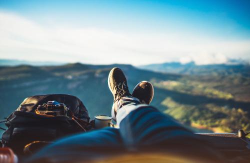 Person with a backpack relaxing on a mountain. 